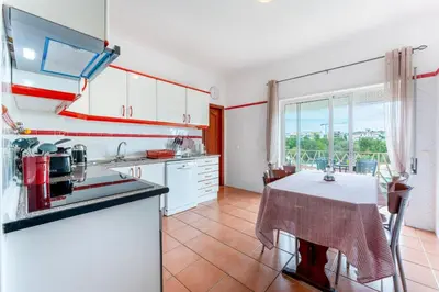 a kitchen with white cabinets and a table with a table cloth at Peaceful 1 BDR Apartment W/ Balcony by LovelyStay in Almancil