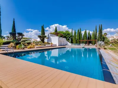 a swimming pool in front of a house at AL - Boho Chic Villa Country Club in Vilamoura