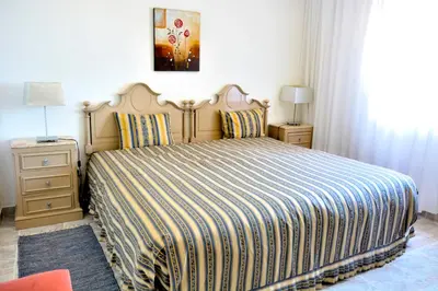 a bedroom with a large bed with a striped blanket at Casa da Horta, Vale carro Olhos de Agua in Albufeira