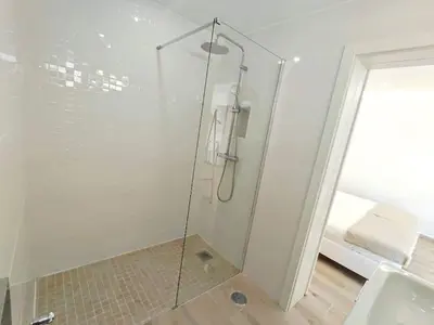 a shower with a glass door in a bathroom at Lovely Terrace Studio Baixa Faro in Faro