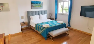 a small bedroom with a bed and a television at Villa Arquete 6 seat Jacuzzi 5 min walk to shops in Guia