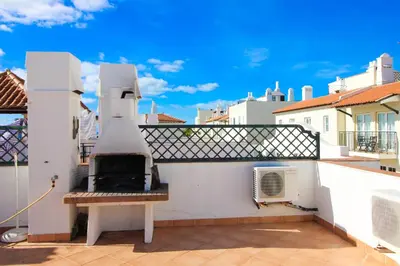 a balcony with a pizza oven on a building at Two bed Old Village E007 in Vilamoura