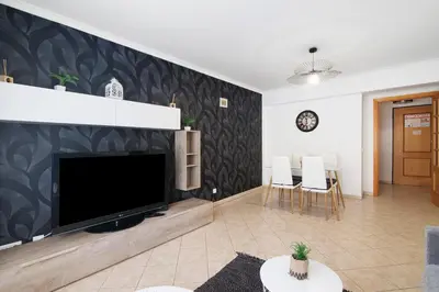 a living room with a large flat screen tv at Apartamento do Sol in Albufeira