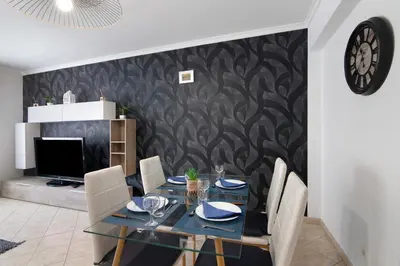 a dining room with a table with chairs and a tv at Apartamento do Sol in Albufeira