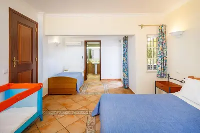 a bedroom with two beds and a bathroom at 7 Bedroom Private Villa Tenazinha II, with pool in Albufeira