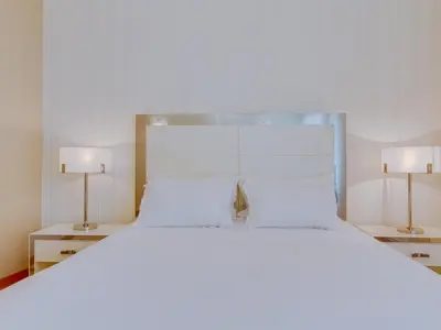 a bedroom with a large white bed with two lamps at AL - Apartamento Moura Praia in Vilamoura