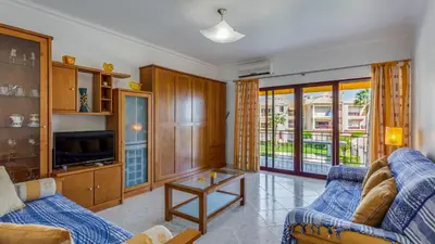 a living room with two blue couches and a tv at Serene Apartment W/ Balcony and Pool by LovelyStay in Quarteira