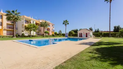 a swimming pool in a yard next to a building at Serene Apartment W/ Balcony and Pool by LovelyStay in Quarteira