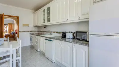 a kitchen with white cabinets and a counter top at Serene Apartment W/ Balcony and Pool by LovelyStay in Quarteira