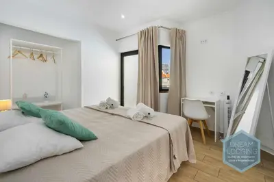 a white bedroom with a bed and a desk at Vila Magna 109 - Dream Lodging in Albufeira