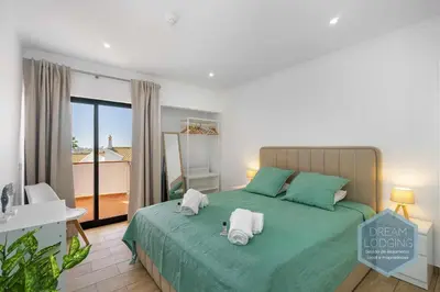 a bedroom with a green bed with towels on it at Vila Magna 109 - Dream Lodging in Albufeira
