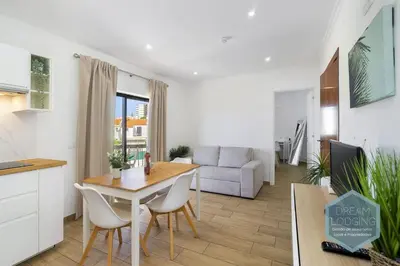 a kitchen and living room with a table and chairs at Vila Magna 109 - Dream Lodging in Albufeira