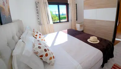 a bedroom with a bed with a hat on it at CH 1 e 2 Two Apartments Up To 10 Guests Casa da Horta, T1 & T2 in Albufeira