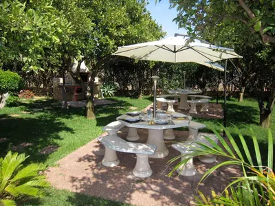 a group of tables and an umbrella in a yard at CH 1 e 2 Two Apartments Up To 10 Guests Casa da Horta, T1 & T2 in Albufeira
