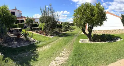 a garden with trees and grass and a building at CH 1 e 2 Two Apartments Up To 10 Guests Casa da Horta, T1 & T2 in Albufeira