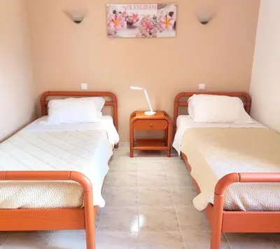 a room with two beds and a table with a lamp at CH 8, 11 e 12 - Casa da Horta 3 x T 1 Apartments Up To 12 Guests in Olhos de Água