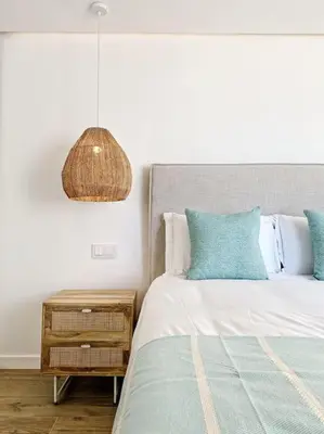 a bedroom with a bed and a nightstand with a lamp at Front Sea Apartment Quarteira in Quarteira