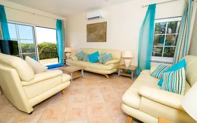 a living room with two couches and two windows at Villa Oliandra in Vilamoura