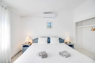 a bedroom with a white bed with two night stands at Modern Oasis 500m Beach with AC WiFi Pool in Albufeira