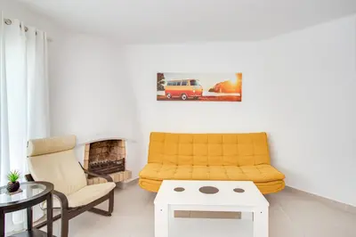 a living room with a yellow couch and a fireplace at Modern Oasis 500m Beach with AC WiFi Pool in Albufeira