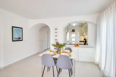 a white kitchen with a table and chairs at Modern Oasis 500m Beach with AC WiFi Pool in Albufeira
