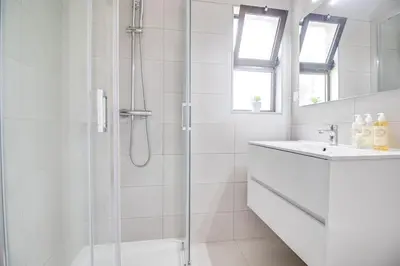 a white bathroom with a shower and a sink at Modern Oasis 500m Beach with AC WiFi Pool in Albufeira