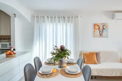 a white living room with a table and chairs at Modern Oasis 500m Beach with AC WiFi Pool in Albufeira