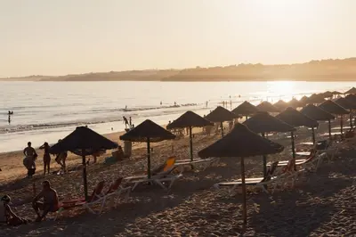 a group of beach umbrellas and chairs on a beach at Açoteias 203 in Albufeira