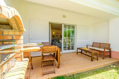 a patio with chairs and a table and a bench at Villa Baya - Great family complex with communal pool in Albufeira