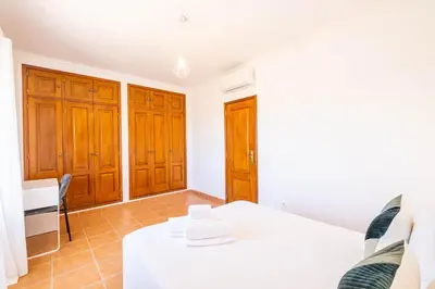 a room with a white table and wooden cabinets at Villa Baya - Great family complex with communal pool in Albufeira