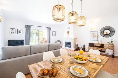 a living room with a couch and a table with food on it at Villa Baya - Great family complex with communal pool in Albufeira