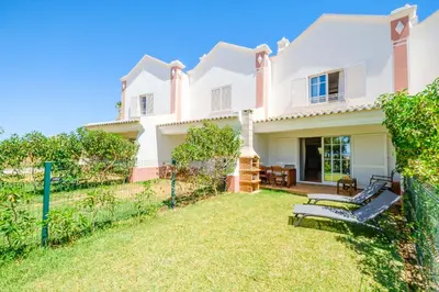 a white house with a fence and a yard at Villa Baya - Great family complex with communal pool in Albufeira
