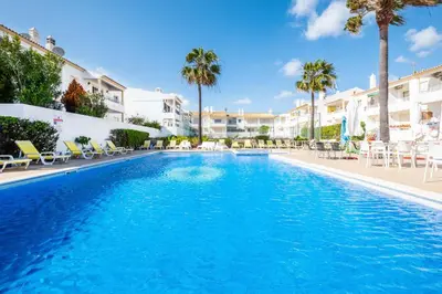a white room with a table and a chair at Apartment Marlena - complex great for families in Albufeira