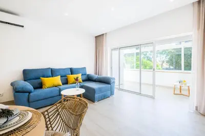a living room with a blue couch and yellow pillows at Apartment Tanta - located at the gates of the old in Albufeira