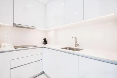a kitchen with white cabinets and a sink at Apartment Tanta - located at the gates of the old in Albufeira