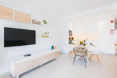 a living room with a table and a tv on a wall at Apartment Tanta - located at the gates of the old in Albufeira