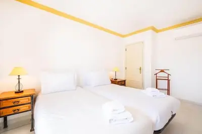 two white beds in a room with two lamps at Villa Redonda in Albufeira