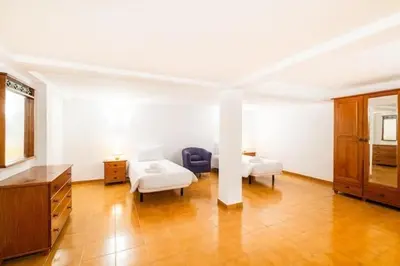 a large room with two beds and a dresser at Villa Redonda in Albufeira
