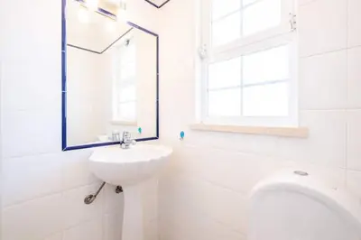 a white bathroom with a sink and a mirror at Villa Redonda in Albufeira