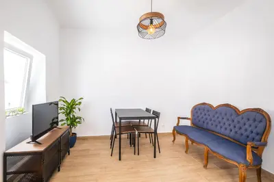 a living room with a blue couch and a table at Apartment Santana - In the heart of Albufeira in Albufeira