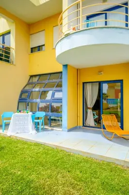 a yellow building with a balcony with a table and chairs at Apartment Mayah - Albufeira marina in Albufeira