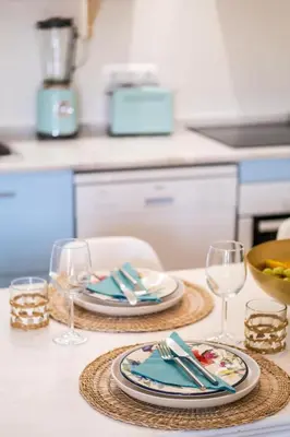 a table with two plates and wine glasses on it at Apartment Mayah - Albufeira marina in Albufeira