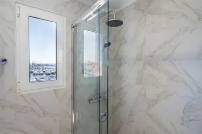 a shower with a glass door and a window at Marina Vision Vilamoura in Vilamoura