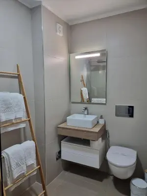 a bathroom with a sink and a toilet and a mirror at Casa Jasmim in Faro