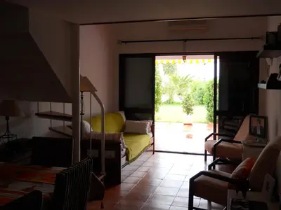 a living room with a staircase and a couch and a table at Casa Linda da Praia do Alfamar in Albufeira