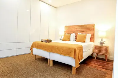 a bedroom with a large bed with a wooden headboard at Green Algarve Gem Spacious 2 BDR By Misha's Place in Faro