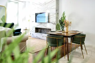 a living room with a table and chairs and a tv at GREEN FARO, MODERN DUPLEX with A BLISS TERRACE in Faro