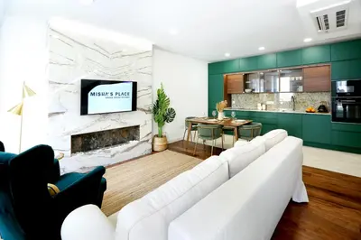 a living room with a white couch and a fireplace at GREEN FARO, MODERN DUPLEX with A BLISS TERRACE in Faro