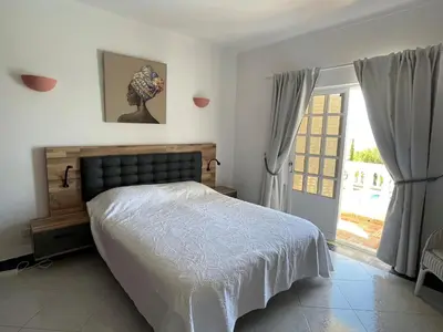 a bedroom with a bed and a large window at Cabana do Monte in Santa Bárbara de Nexe