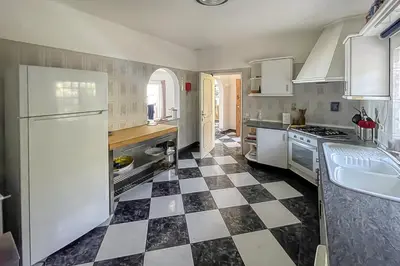 a kitchen with a black and white checkered floor at Cabana do Monte in Santa Bárbara de Nexe